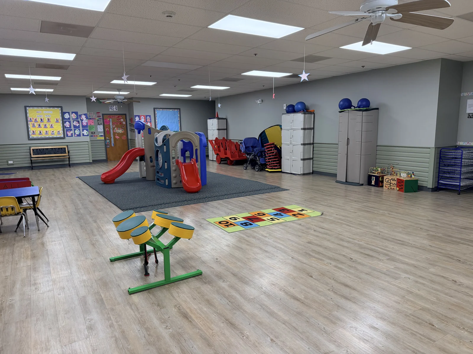 Indoor play area with climbing equipment, slides, activity toys, and open space for movement