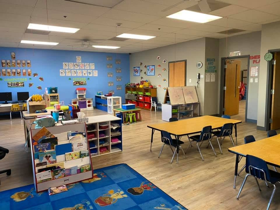 Pre-K Room with books, learning tables, dramatic-play materials, and a computer center